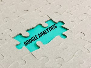 google analytics written in black on teal background between puzzle pieces