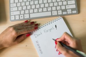 person writing don't forget with a list to schedule