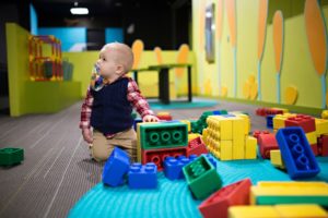 little boy playing at daycare with lego blocks