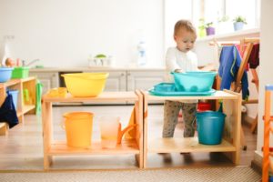 toddler playing with water and objects at daycare