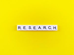 yellow background with white scrabble tiles and black letters that say research